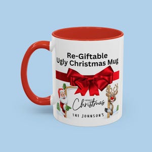 May include: A white ceramic mug with a red interior and handle. The mug features the text "Re-Giftable Ugly Christmas Mug" with a red bow and festive illustrations of Santa and a reindeer. The words "Merry Christmas" and a family name are also included.