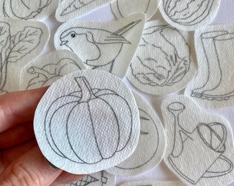 May include: A set of 14 black and white line drawings of various garden items, including a wheelbarrow, a carrot, a pumpkin, a bird, a watering can, a cabbage, a garlic, a squash, a boot, a shovel, and a leaf. The drawings are on a white background.