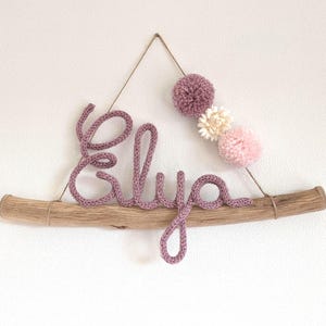Nombre de bebé tejido en madera flotante con pompones y flores secas blancas naturales / nombre tejido en madera flotante