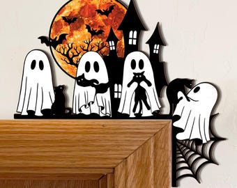 May include: A black and white Halloween-themed wooden decoration featuring ghosts, a haunted house, bats, and a full moon. The decoration is placed on a wooden door frame, with a spider web on the corner. The design is from Queen of Mercy US.