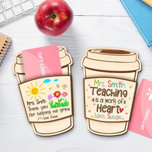 May include: Two wooden coffee cup-shaped gift card holders. One has a drawing of a sun, flowers, and the text "Mrs. Smith, Thank you for helping me grow, Love, Susan." The other says "Mrs. Smith, Teaching is a work of Heart, Love, Susan."