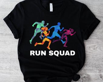 Op de afbeelding: Zwart t-shirt met een afbeelding van vijf hardlopers in beweging, weergegeven in groen, oranje, blauw en roze. De tekst "RUN SQUAD" is eronder in het wit gedrukt, wat een dynamisch ontwerp creëert.