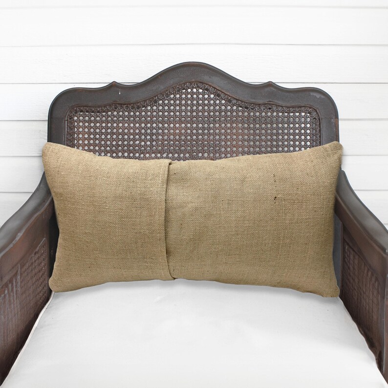 A brown wooden chair with a woven headrest and a beige pillow on the seat.