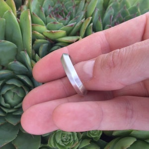 Peut inclure: Une bague en argent avec un design g&eacute;om&eacute;trique facett&eacute;. La bague est montr&eacute;e sur un doigt.