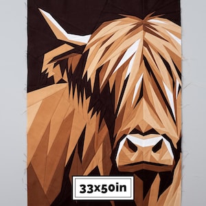 Könnte beinhalten: Ein geometrischer Stoff-Quiltblock mit einem Highland-Rinder-Porträt in Braun-, Beige- und Weißtönen. Das Design besteht aus kantigen Stoffstücken mit sichtbaren Nähten. Ein weißes rechteckiges Etikett zeigt den Text 33x50in.