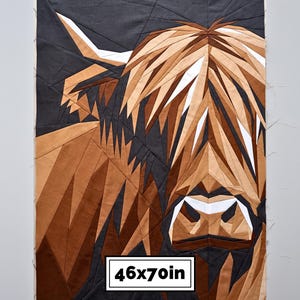 May include: A rectangular fabric quilt featuring a geometric, pieced Highland cow portrait in shades of brown, tan, black, and white. The design is composed of angular fabric segments. A white label at the bottom displays the text 46x70in.