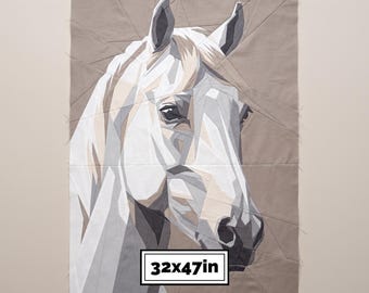 May include: A geometric fabric quilt panel featuring a stylized horse head in shades of white, gray, and beige. The design is composed of angular fabric pieces stitched together. A rectangular label at the bottom displays the text 32x47in.