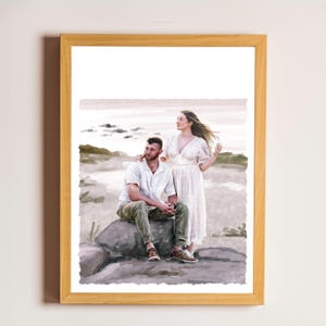 May include: A framed watercolour-style print depicting two individuals outdoors. One person sits on a large rock wearing a white short-sleeved shirt and olive green trousers, while the other stands beside them in a long, flowing white dress.