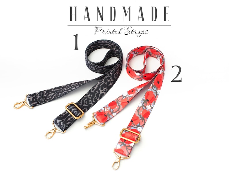 May include: Two handmade printed straps. One strap is black with a leopard print and the other is white with red flowers. Both straps have gold hardware.