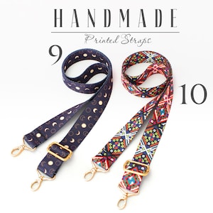 May include: Two handmade printed straps, one with a moon and star pattern in navy blue and white, and the other with a colorful geometric pattern. The straps are both adjustable and have gold hardware.