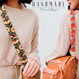 May include: Two women wearing beige sweaters with adjustable straps. The straps are made of fabric with floral prints. One strap has a red floral print and the other has a yellow floral print. Both women are wearing brown leather bags.