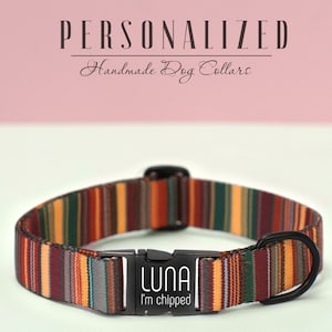 K&ouml;nnte beinhalten: Ein personalisiertes Hundehalsband mit einem gestreiften Muster in Rot-, Orange-, Gelb-, Gr&uuml;n- und Graut&ouml;nen. Das Halsband hat eine schwarze Schnalle und ein schwarzes Metallschild mit der Aufschrift "LUNA I'm chipped".