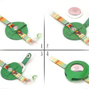 May include: A green leather collar with a round, green leather pouch that opens to reveal a small, round, white disc with a pink apple logo. The collar has a colorful, geometric pattern.
