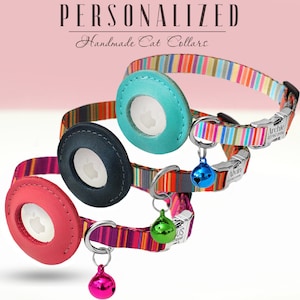Op de afbeelding: Drie kleurrijke kattenhalsbanden met gepersonaliseerde naamplaatjes en belletjes. De halsbanden zijn gestreept in verschillende kleuren, waaronder roze, blauw, groen en geel. De naamplaatjes zijn rond en hebben een transparant venster voor de naam. De belletjes zijn zilverkleurig en hebben een kleine, ronde vorm.