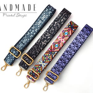 May include: Four different patterned straps with gold hardware. The straps are made of fabric and have a variety of colors and designs. The straps are handmade and are perfect for adding a touch of personality to any bag or purse.