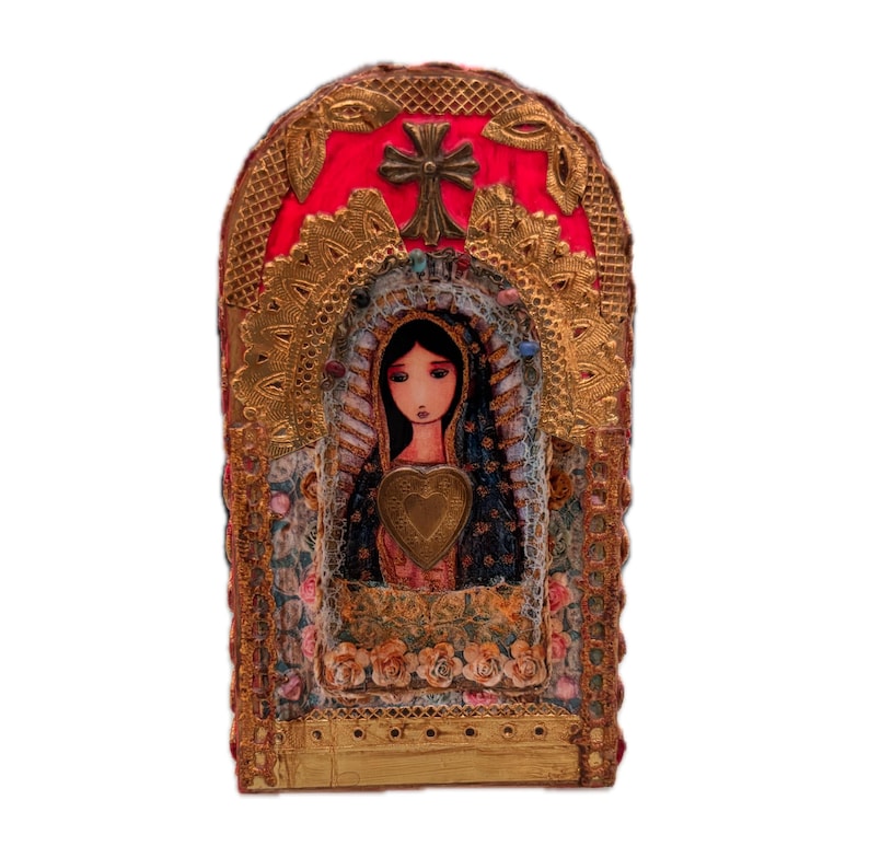 K&ouml;nnte beinhalten: Aufwendige religi&ouml;se Ikone mit einem zentralen Bild einer Frau mit einem herzf&ouml;rmigen Emblem. Die Ikone ist mit Goldfiligran, einem roten Hintergrund und einem Kreuz oben gerahmt. Blumen- und Spitzendetails sorgen f&uuml;r Textur und Farbe.