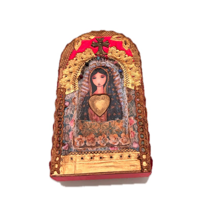 K&ouml;nnte beinhalten: Dekorative religi&ouml;se Ikone mit einem zentralen Bild einer Frau mit einem herzf&ouml;rmigen Emblem. Die Ikone hat eine rote Basis und Oberseite, goldene Akzente und ein Kreuz. Der Hintergrund zeigt florale Muster und goldene Verzierungen.