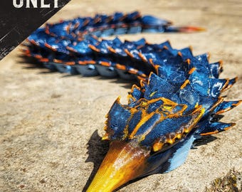 May include: A detailed, 3D-printed model of a stylized creature with a long, segmented body. The model features a vibrant color scheme of blue, orange, and yellow. The text "DIGITAL FILE ONLY" is visible in the upper left corner.