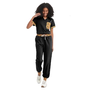 May include: Black scrub top and pants set with a colorful patterned trim. The top has a V-neck and a pocket on the left side. The pants have a drawstring waistband.
