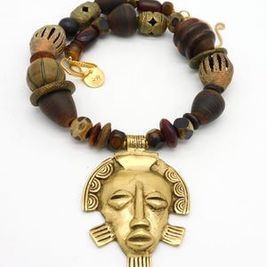 Collana con maschera tribale: ciondolo in corno, osso e ottone intagliato a mano.