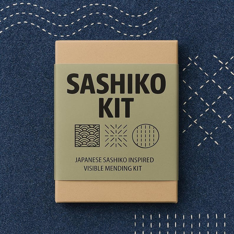 Puede incluir: Una caja marr&oacute;n con una etiqueta verde que dice "Sashiko Kit" y "Japanese Sashiko Inspired Visible Mending Kit". La etiqueta tambi&eacute;n tiene tres peque&ntilde;as ilustraciones de diferentes patrones de costura.