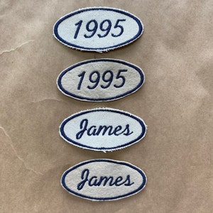 May include: Four oval-shaped fabric patches with blue stitching. Two patches say "1995" in blue cursive lettering. Two patches say "James" in blue cursive lettering.
