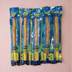 May include: Five individually packaged Miswak natural toothbrushes. Each toothbrush is a light brown colour and is sealed in a blue and clear plastic package. The packaging has the word "Miswak" printed on it.