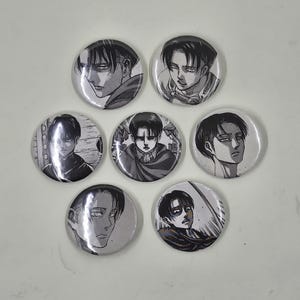 May include: A set of seven circular pin-back buttons featuring black and white manga-style illustrations of a character with dark hair and a serious expression. Each button displays a different close-up portrait or action pose of the same individual.