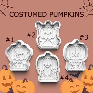 May include: White plastic cookie cutters in the shape of costumed pumpkins. The cutters are numbered 1 through 4. The text "COSTUMED PUMPKINS" is at the top. Orange pumpkins are at the bottom.