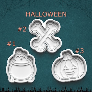 May include: Three white plastic cookie cutters on a dark teal background. Item #1 is a bubbling cauldron, item #2 is a pair of crossed bones, and item #3 is a jack-o'-lantern pumpkin. The word HALLOWEEN is printed in light orange at the top.