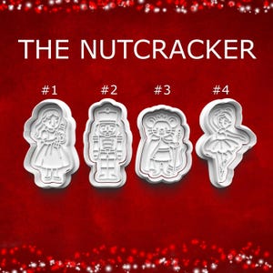 May include: Four white plastic cookie cutters in the shape of characters from The Nutcracker ballet. The shapes include a girl, a nutcracker soldier, a mouse king, and a ballerina. The text "THE NUTCRACKER" is at the top.