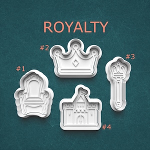 May include: Four white plastic cookie cutters in the shapes of royal items. The shapes include a throne, a crown, a scepter, and a castle. The word "ROYALTY" is printed in orange at the top of the image.