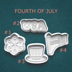 May include: Four white plastic cookie cutters in patriotic shapes: a firework, the word "USA", a top hat, and an American flag. The text "FOURTH OF JULY" is above the cutters. Each cutter is numbered.
