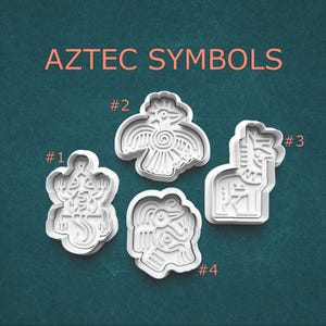 May include: Four white plastic cookie cutters shaped like Aztec symbols. The cutters are numbered 1 through 4. The symbols are a lizard, a bird, a llama, and a bird with a serpent.