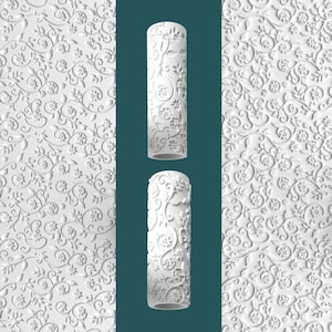May include: White, cylindrical rolling pin with a floral pattern. The rolling pin is displayed with a matching floral patterned background. The design features detailed embossed flowers and vines. The rolling pin is approximately 10 inches long.