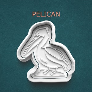 May include: White plastic cookie cutter shaped like a pelican. The cutter has a detailed outline of the pelican with a long beak and a pouch under its beak.