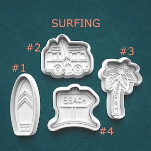 May include: Four white plastic cookie cutters with a surfing theme. The shapes include a surfboard, a van with a surfboard, a palm tree, and a sign that says "BEACH". The word "SURFING" is printed in orange.