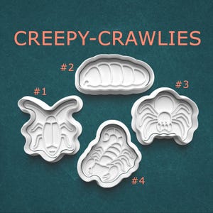 May include: Four white plastic cookie cutters labeled CREEPY-CRAWLIES. Number 1 is a beetle, number 2 is a grub, number 3 is a spider, and number 4 is a scorpion. Each cutter features a detailed outline and internal impression design for shaping dough.