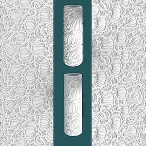 May include: White rolling pin with a carved pumpkin and leaf pattern. The design is repeated on the surface of the pin and on the adjacent background. The pin is cylindrical and features a detailed, embossed design, perfect for baking.
