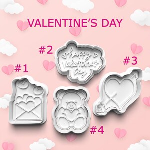 May include: White plastic cookie cutters in Valentine's Day shapes. Designs include an envelope with hearts, a cloud with "Happy Valentine's Day" text, a heart pierced by an arrow, and a teddy bear holding a heart. The background is pink with hearts and clouds.
