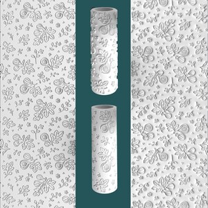 May include: A white cylindrical patterned rolling pin featuring a raised relief design of fig fruits, leaves, and small flowers. The surface texture is repeated across the entire length of the tool, creating a consistent botanical motif for imprinting.