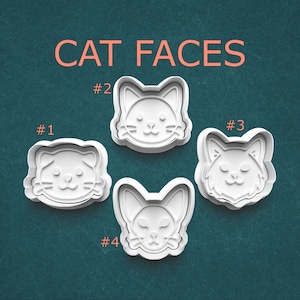 May include: Four white plastic cat face cookie cutters. The text "CAT FACES" is in orange above the cutters. Each cutter is numbered: #1, #2, #3, and #4. The cutters are on a teal background.