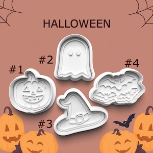 May include: White Halloween-themed cookie cutters in the shapes of a jack-o'-lantern, ghost, witch hat, and bats. The word "HALLOWEEN" is printed in black at the top. Orange pumpkins are in the background.