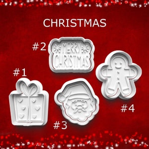 May include: White plastic Christmas-themed cookie cutters. The set includes a gift box, a "Merry Christmas" sign, a Santa Claus face, and a gingerbread man. The word "CHRISTMAS" is written in white at the top.