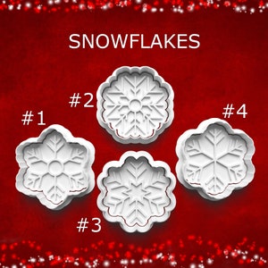 May include: Four white snowflake-shaped cookie cutters against a red background. The word "SNOWFLAKES" is at the top. Each cutter is numbered from 1 to 4. The cutters have different snowflake designs.