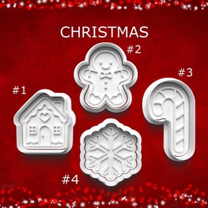 May include: Four white Christmas-themed cookie cutters on a red background. The cutters include a house, gingerbread man, candy cane, and snowflake. The word "CHRISTMAS" is at the top.