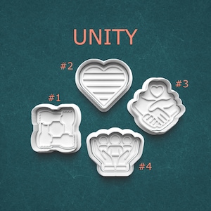 May include: Four white plastic cookie cutters with the word "UNITY" in orange. The cutters are shaped as a heart, two hands holding a heart, a group of people in cupped hands, and a design with interlocking shapes.