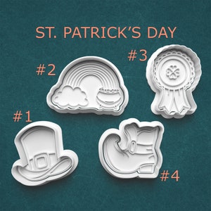 May include: Four white plastic cookie cutters for St. Patrick's Day. Designs include a leprechaun hat, a rainbow with a pot of gold, a ribbon with a shamrock, and a leprechaun boot. The words "ST. PATRICK'S DAY" are at the top.