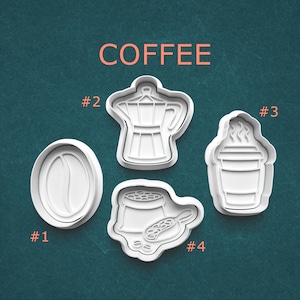 May include: Four white plastic cookie cutters in coffee-themed shapes: a coffee bean, a stovetop espresso maker, a to-go coffee cup, and a bag of coffee beans with a scoop. The word "COFFEE" is printed above the cutters.