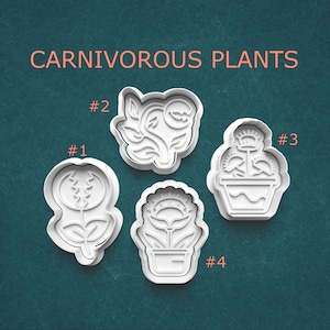 May include: Four white plastic cookie cutters in the shapes of carnivorous plants, including a Venus flytrap and pitcher plant. The text "CARNIVOROUS PLANTS" is in orange above the cutters. Each cutter is labeled with a number.